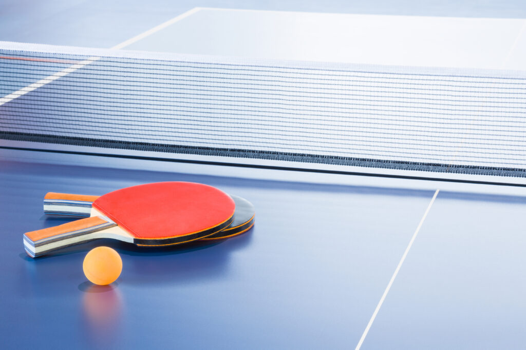 paddles and ball on blue table