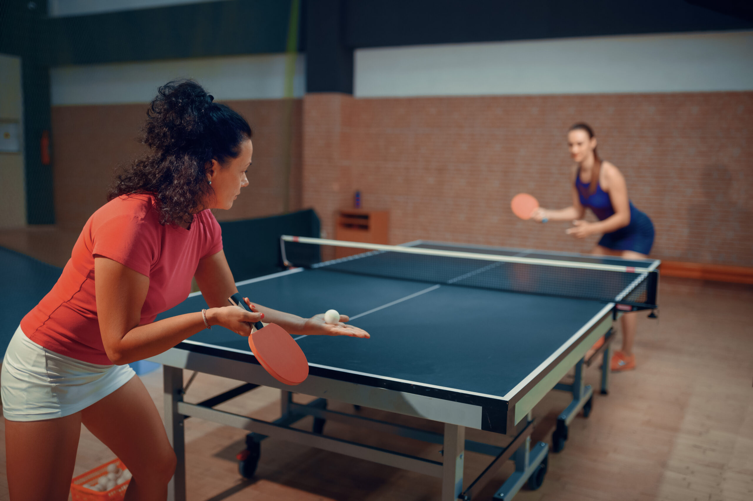 women serving ping pong ball for gaming