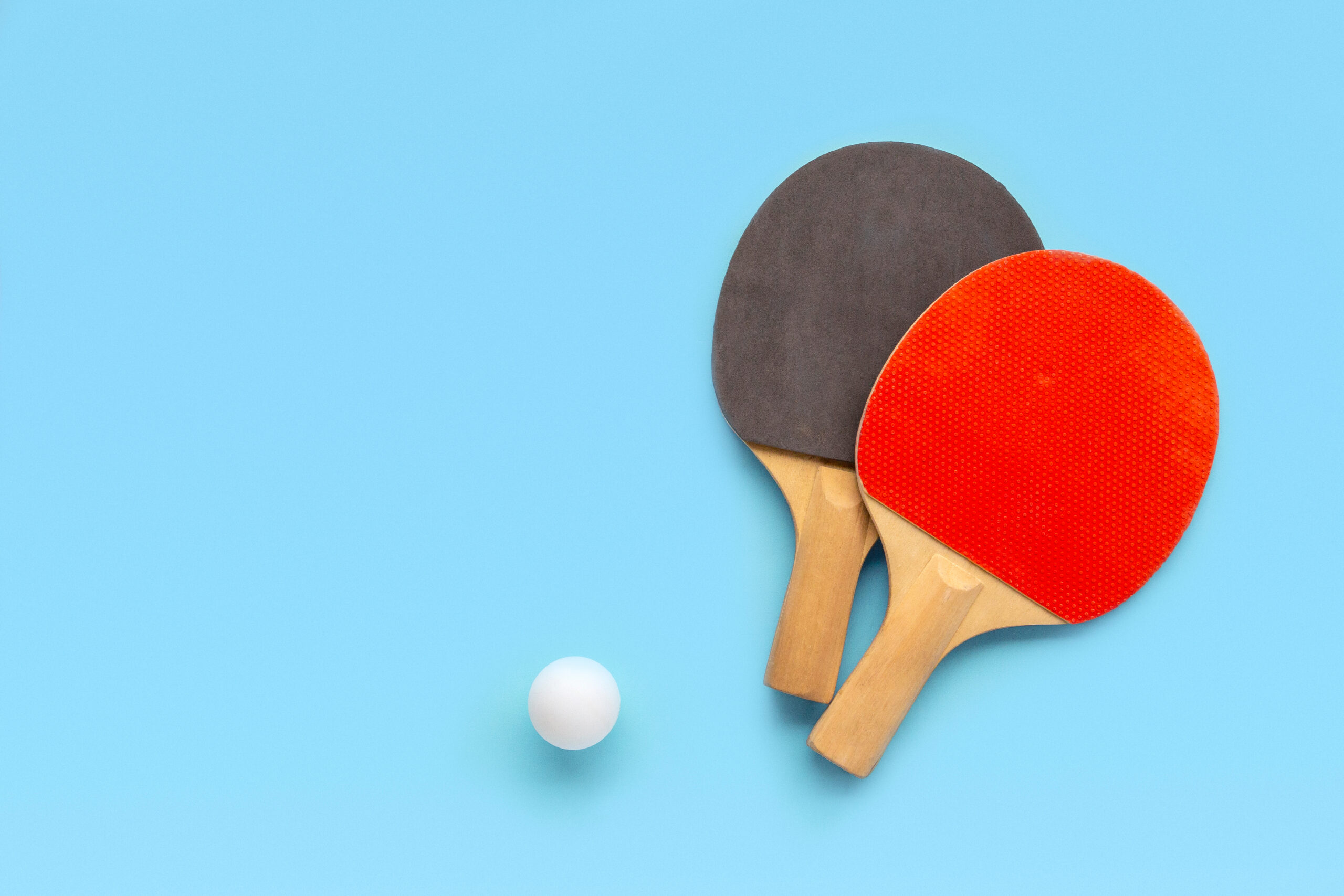 red and black paddles with white ball